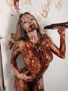 Голая девушка в шоколаде ласкает большие сиськи